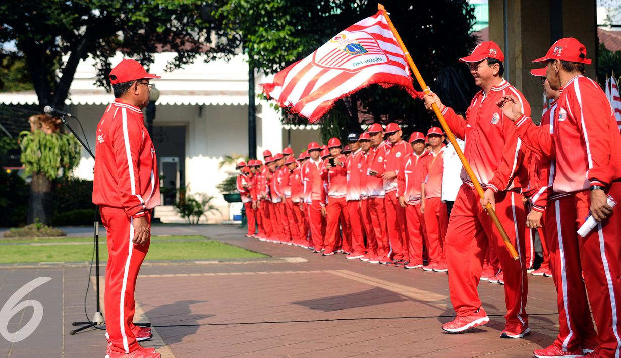 Gubernur DKI Jakarta, Basuki Tjahaja Purnama (kedua kanan) menyerahkan bendera kontingen kepada ketua tim yang akan berlaga di PON XIX Jabar di halaman Balaikota Jakarta, Rabu (7/9). DKI Jakarta menerjunkan 1.258 atlet. (Liputan6.com/Helmi Fithriansyah)