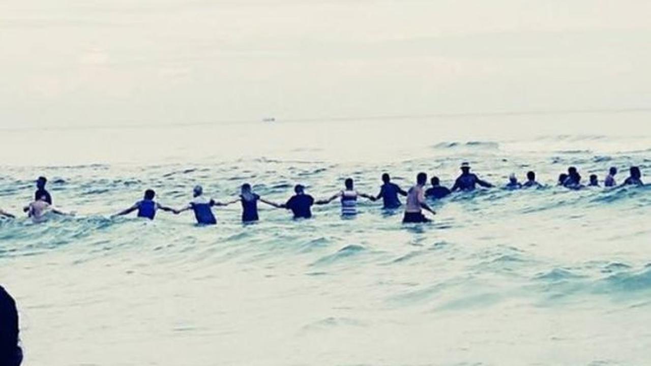 Rantai manusia di pantai Florida untuk menyelamatkan sebuah keluarga. (Facebook/Rosalind Beckton)
