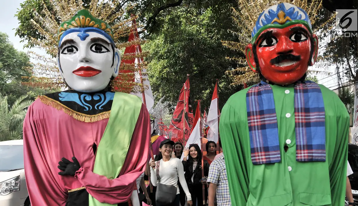 Sejumlah wanita membawa bendera saat memeriahkan arak-arakan PDIP menuju Kantor KPU, Jakarta, Selasa (17/7). Kedatangan anggota PDIP untuk mendaftarkan bakal caleg di KPU diiringi pawai bendera, ondel-ondel, musik. (Merdeka.com/Iqbal S. Nugroho)