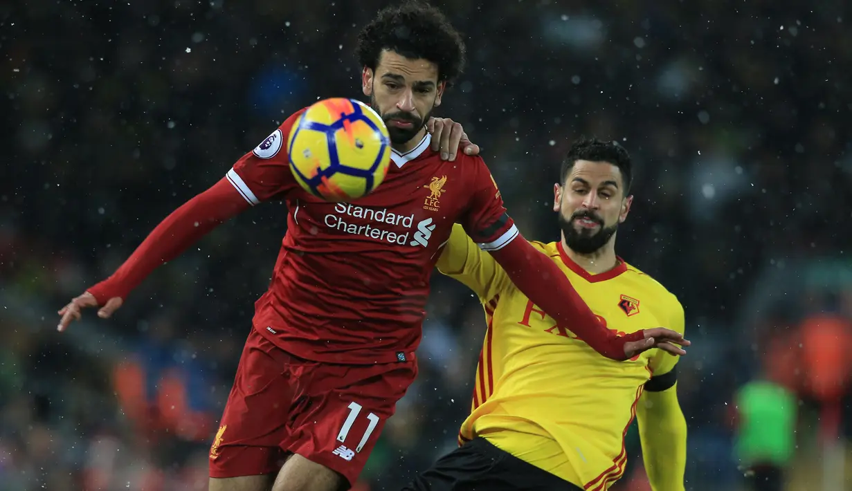 Gelandang Liverpool, Mohamed Salah berusaha melewati gelandang Watford, Etienne Capoue pada laga Premier League di Stadion Anfield, Liverpool, Sabtu (17/3/2018). Liverpool menang 5-0 atas Watford. (AFP/Lindsey Parnaby)