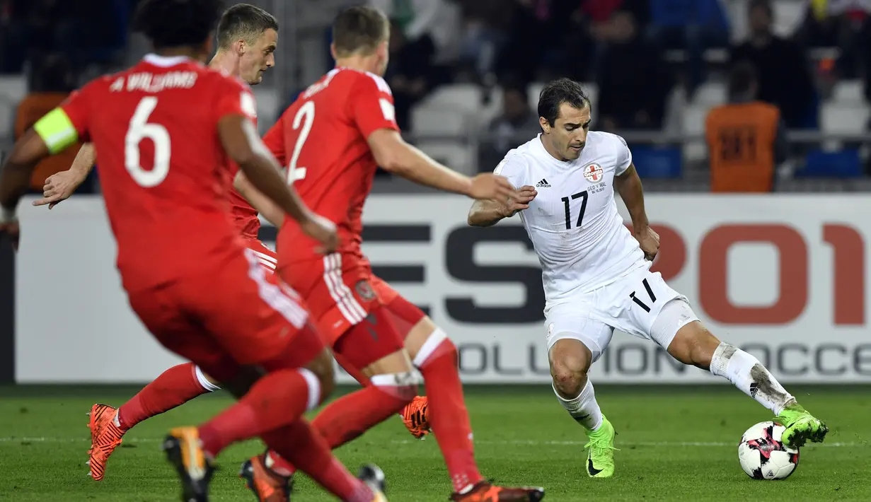 Aksi pemain Georgia, Giorgi Merebashvili menerobos pertahanan Wales pada kualifikasi Piala Dunia 2018 grup D di Boris Paichadze Dinamo Arena, Tbilisi (06/10/2017). Wales menang 1-0. (AFP/Alexander Nemenov)