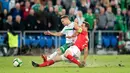 Gelandang Irlandia Utara, Jamie Ward dan pemain Swiss, Stephan Lichtsteiner berebut bola pada playoff Piala Dunia 2018 zona Eropa di St Jakob Park Stadium, Minggu (12/11). Swiss akhirnya lolos ke Piala Dunia 2018. (Laurent Gillieron/Keystone via AP)