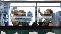 Pemain timnas softball Australia melambai kepada media dari bus mereka setibanya di Bandara Internasional Narita, Jepang, Selasa (1/6/2021). Timnas softball Australia termasuk di antara yang paling awal datang untuk Olimpiade Tokyo. (AP Photo/Eugene Hoshiko, Pool)