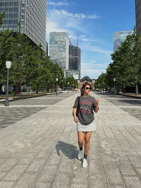 Gaya liburan Raisa yang simpel mengenakan kaus abu-abu dan rok mini bernuansa senada. [Foto: Instagram/raisa6690]