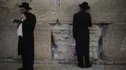 Dua orang Yahudi berdoa di Tembok Ratapan, situs paling suci di Kota Tua Yerusalem (16/2/2020). Ketika kekhawatiran tentang penyebaran virus corona meningkat, umat Yahudi yang setia mengadakan sesi doa untuk mencari intervensi ilahi untuk membantu mencegah penyakit tersebut. (AP Photo/Ariel Schalit)