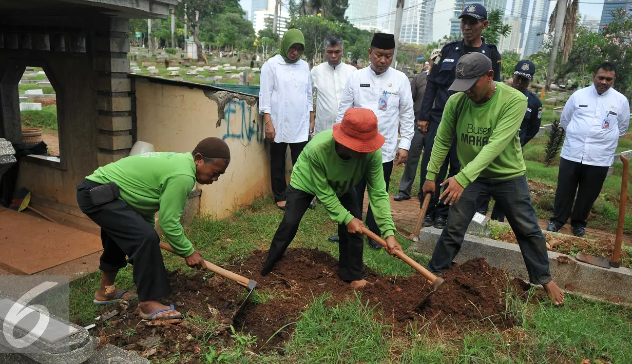 Pekerja membongkar makam fiktif di Tempat Pemakaman Umum (TPU) Menteng Pulo, Jakarta Selatan, Kamis (28/7). 4 makam di bongkar dari total terindikasi 14 makam fiktif yang ditemukan di TPU tersebut. (Liputan6.com/Gempur M Surya)