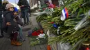 Warga Moskow melihat karangan bunga di luar Kedutaan Besar Prancis di Moskow, Sabtu (14/11/2015) . Karangan bunga tersebut untuk menghormati para korban serangan mematikan di Paris. (AFP Photo/Dmitry Serebryakovi)