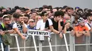 Para suporter bersiap menyambut kedatangan bintang baru Juventus, Cristiano Ronaldo, saat akan menjalani tes kesehatan di area Stadion Allianz, Turin, Senin (17/7/2018). CR 7 hijrah dari Real Madrid ke Juventus. (AFP/Miguel Medina)