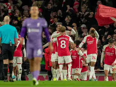 Para pemain Arsenal melakukan selebrasi setelah rekan setimnya Leandro Trossard mencetak gol ketiga tim mereka selama pertandingan sepak bola Liga Premier Inggris melawan Liverpool di Stadion Emirates, London, Minggu, 4 Februari 2024. (AP Photo/Kin Cheung)