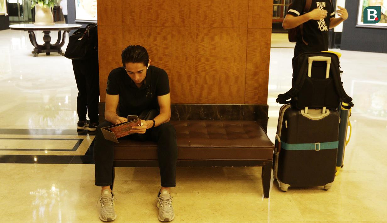 Pemain Indonesia, Gavin Kwan, memainkan handphone sebelum meninggalkan penginapan usai pertandingan terakhir Piala AFF 2018 melawan Filipina di Hotel Sultan, Jakarta, Senin (25/11). Indonesia gagal lolos fase grup Piala AFF. (Bola.com/M Iqbal Ichsan)