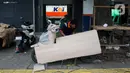 Pekerja mengemas motor untuk dikirim melalui salah satu jasa pengiriman logistik di kawasan Pasar Senen, Jakarta, Minggu (23/3/2025). (Liputan6.com/Herman Zakharia)