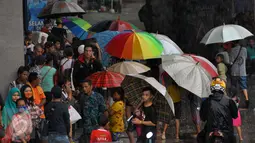 Sejumlah pengojek payung di salah satu tempat perbelanjaan di kawasan Tanah Abang, Jakarta, Selasa (9/2). Pada musim hujan seperti banyak pengojek payung dadakan yang mayoritas adalah anak-anak. (Liputan6.com/Faisal R Syam)