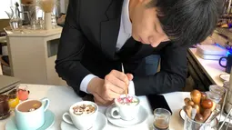 Foto pada 1 Maret 2018 memperlihatkan barista Korsel, Lee Kang-Bin menyelesaikan seni melukis latte di kedai kopi, Seoul. Lee menggunakan sikat dan sendok kecil untuk melukis dan menyebarkan krem tebal yang diwarnai pewarna makanan. (AP/Dino Hazell)
