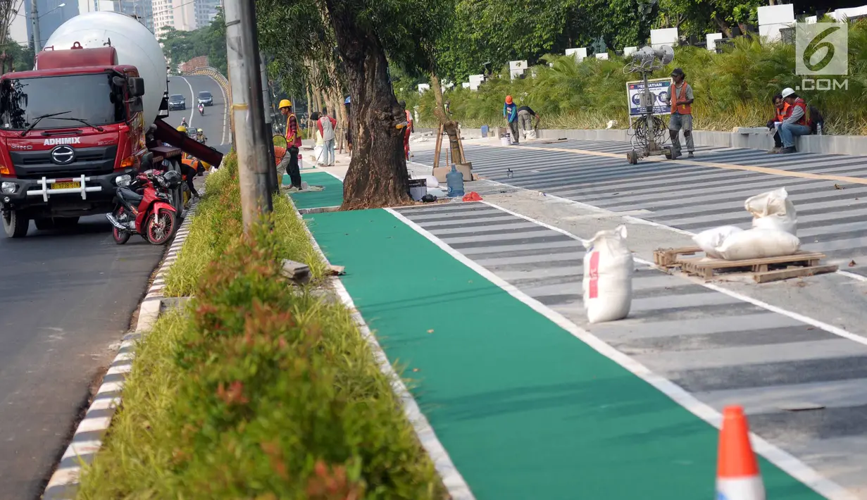 Sejumlah pekerja melakukan pengerjaan tahap akhir renovasi trotoar di sekitar Jalan Gerbang Pemuda, Senayan, Jakarta, Selasa (29/5). Renovasi sebagai bagian persiapan pelaksanaan Asian Games 2018. (Liputan6.com/Helmi Fithriansyah)