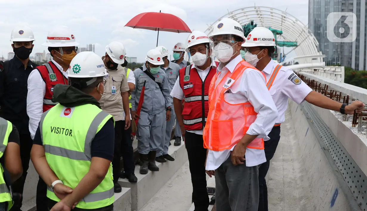 Menteri Perhubungan, Budi Karya Sumadi (kanan) saat meninjau Jembatan Bentang Panjang Dukuh Atas LRT Jabodebek, Jakarta, Minggu (29/11/2020). Saat ini progres pembangunan LRT Jabodebek sudah mencapai 79,52 persen dan ditarget akan beroperasi pada pertengahan 2022. (Liputan6/Helmi Fithriansyah)