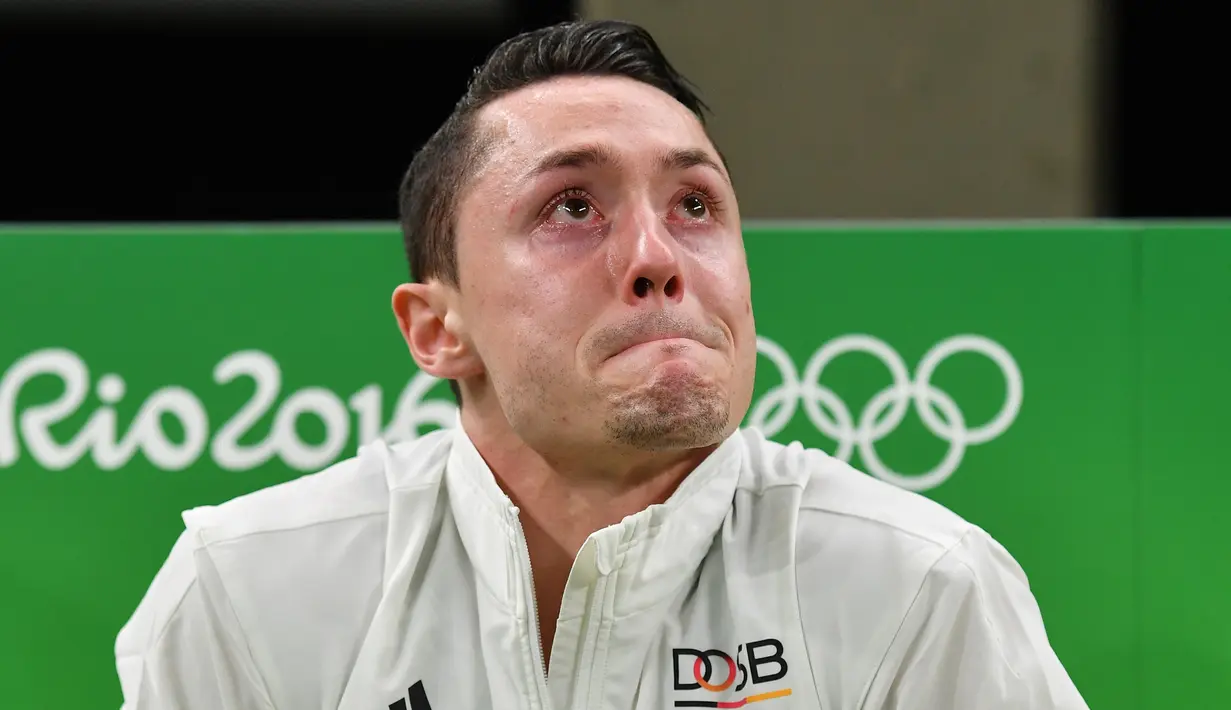Mata atlet senam Jerman, Andreas Toba berkaca-kaca saat harus keluar dan beristirahat panjang untuk memulihkan kondisinya akibat cedera yang dialaminya pada latihan selama Olimpiade Rio 2016, 6 Agustus 2016. (AFP PHOTO/Ben STANSALL)