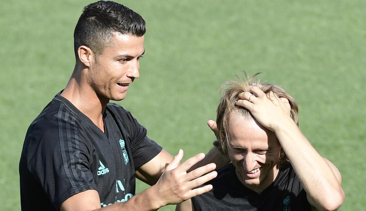 Cristiano Ronaldo saat bercanda bersama Luca Modric saat sesi latihan di Real Madrid sport city, (15/8/2017). Real Madrid akan melawan Barcelona pada leg kedua Piala Super Spanyol. (AFP/Javier Soriano)