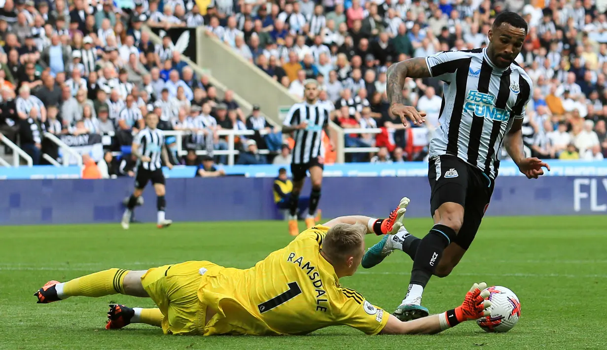 Penjaga gawang Arsenal, Aaron Ramsdale (kiri), berhasil menghalau bola serangan dari pemain Newcastle United, Callum Wilson, dalam laga pekan ke-35 Premier League 2022/2023 yang berlangsung di St James Park, Minggu (7/5/2023). (AFP/Lindsey Parnaby)