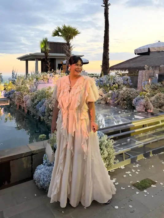 Okky Lukman hadir mengenakan long dress putih dengan aksen renda depan dipadukan anting-anting mutiara besar. [@okidatanglagi]