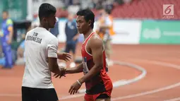 Pelari cepat Indonesia, Lalu Muhammad Zohri (kanan) usai kualifikasi lari 100 meter Asian Games 2018 di Stadion GBK, Jakarta, Sabtu (25/8). Lalu M Zohri mencatat waktu 10,27 detik dan berhak tampil di semifinal. (Liputan6.com/Helmi Fithriansyah)