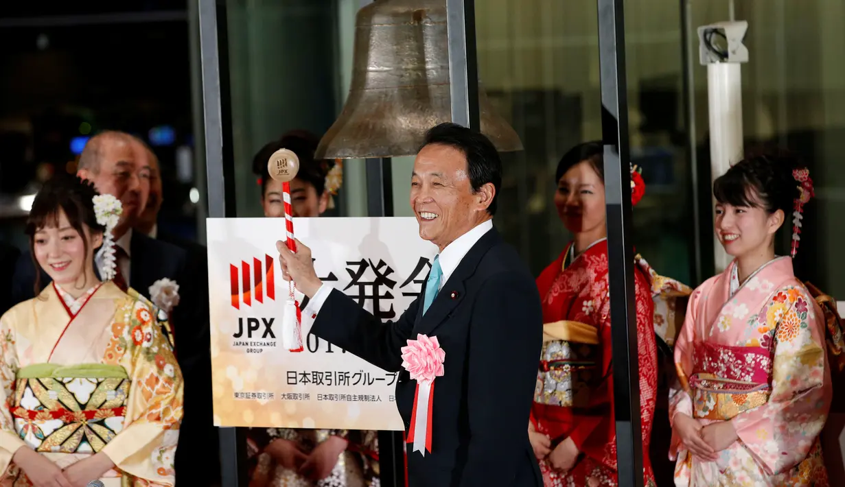Wakil Perdana Menteri Jepang sekaligus Menteri Keuangan Jepang, Taro Aso didampingi gadis berkimono saat pembukaan tahun baru Bursa Efek Tokyo (TSE), Jepang (4/1).  (Reuters/Kim Kyung-Hoon)