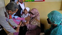 Orangtua, guru, dan polisi mencoba menenangkan seorang siswa saat akan disuntik pada kampanye vaksinasi COVID-19 di sebuah sekolah untuk anak-anak berkebutuhan khusus di Depok, Jawa Barat, Selasa (11/1/2022). Kampanye vaksinasi ini dilakukan oleh Polri. (AP Photo/Dita Alangkara)