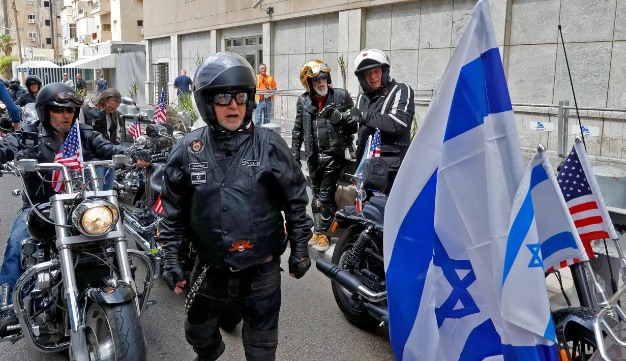 Anggota geng motor Israel Samson Riders beristirahat sebelum menuju Kedutaan Besar AS yang baru di Yerusalem saat melakukan konvoi dari Tel Aviv, (13/5). Mereka memasang bendera AS dan Israel di motoR. (AFP Photo/Jack Guez)