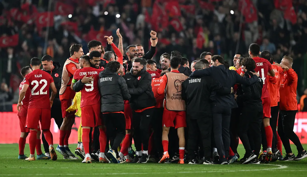 Sejumlah pemain, pelatih, dan ofisial Timnas Turki melakukan selebrasi setelah menang 4-0 atas Latvia pada laga Grup D Kualifikasi Euro 2024 di Konya Buyuksehir Belediye Stadium, Konya, Turki, Senin (16/10/2023) dini hari WIB. (AFP/Ozan Kose)