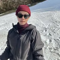 Di tengah salju, Yura tampil dengan jaket hitam dipadukan inner turtleneck warna maroon yang serasi dengan bennienya. Ia pun menambahkan kacamata hitam pada wajahnya yang tanpa makeup. Credit: Instagram (@yurayunita)