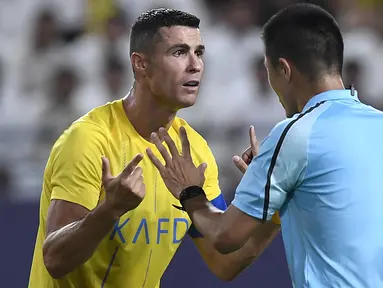 Pemain Al-Nassr, Cristiano Ronaldo (kiri) melakukan protes terhadap keputusan wasit yang memimpin laga play off Liga Champions Asia 2023/2024 antara Al-Nassr melawan Al-Ahli Dubai di KSU Stadium, Rabu (23/8/2023) WIB. (AFP/Yazid al-Duwihi)