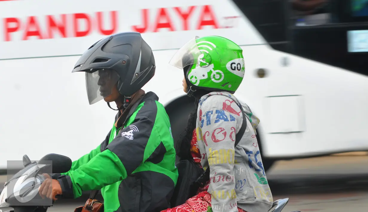 Pengendara ojek online bersama penumpang melintas di kawasan Terminal Kalideres, Jakarta, Selasa (22/3). Dengan adanya aksi demo angkutan umum di ruas Jakarta penumpang terlantar di sejumlah terminal. (Liputan6.com/Faisal R Syam)