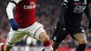 Pemain Arsenal, Mesut Ozil (kiri) berusaha melewati adangan pemain Crystal Palace, Patrick van Aanholt pada lanjutan Premier League di Emirates stadium, London, (20/1/2018). Arsenal menang 4-1. (AP/Frank Augstein)