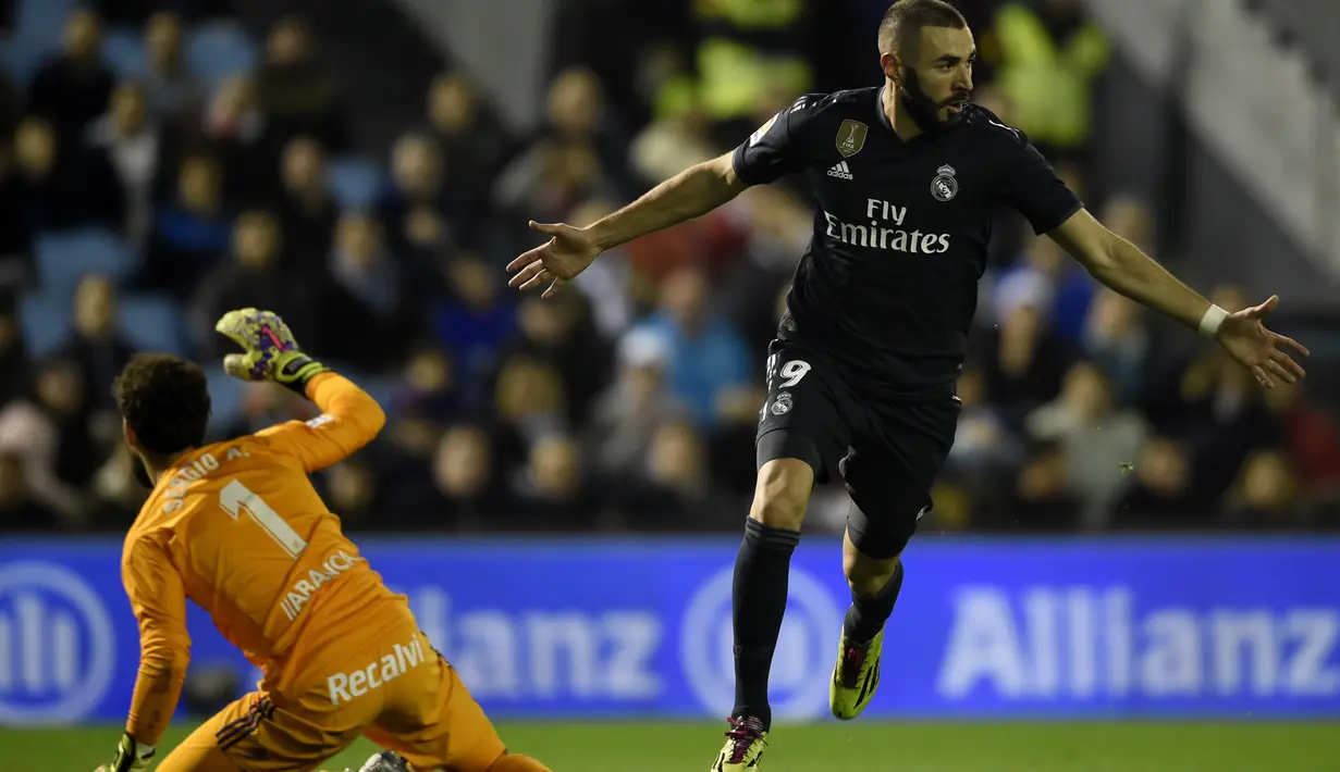 Selebrasi penyerang Real Madrid, karim benzema usai menciptakan gol pertama bagi Real Madrid pada laga lanjutan pekan ke-12 La Liga 2018/19, Senin (12/11) yang berlangsung di stadion Balaidos, Spanyol. Celta Vigo tumbang 2-4. (AFP/Miguel Riopa)