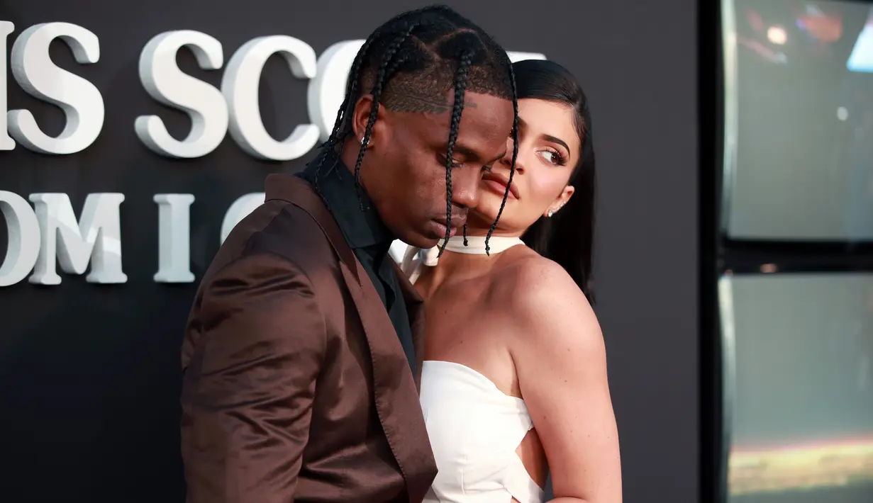 Travis Scott (kiri) berpose bersama Kylie Jenner saat menghadiri pemutaran perdana Netflix "Travis Scott: Look Mom I Can Fly" di Barker Hangar, Santa Monica, California, Amerika Serikat, Senin (27/8/2019). Scott dan Kylie tampak mesra di depan kamera. (Rich Fury/GETTY IMAGES NORTH AMERICA/AFP)