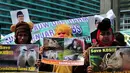 Massa memakai kostum badut-badut satwa dalam aksi di Bundaran HI, Jakarta, Senin (8/12/2014). (Liputan6.com/Johan Tallo)
