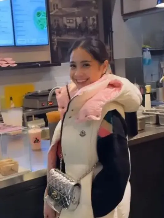 Nagita mengenakan padding vest putih dari Moncler seharga Rp19 jutaan. Ia membawa tas Chanel warna silver.  [@raffinagita1717]