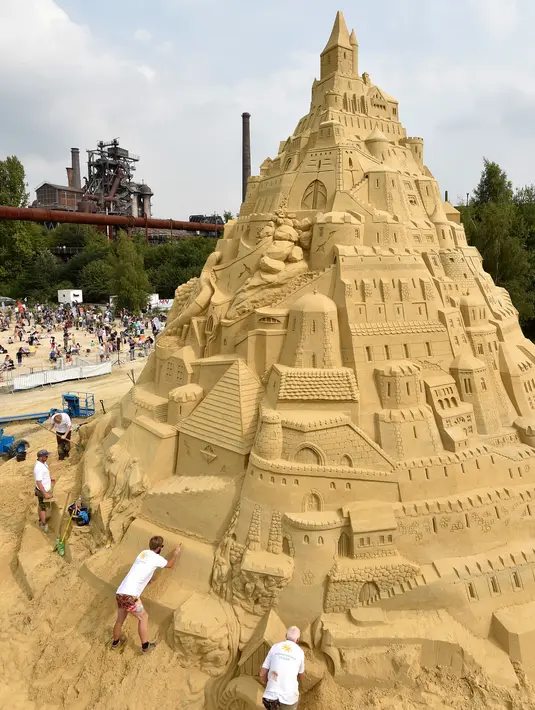 Sejumlah seniman saat menyelesaikan istana pasir di Landschaftspark di Duisburg, Jerman , (1/9). Seniman dari Duisburg burusaha meraih Guinness Book of World Records dengan membuat istana pasir tertinggi yang pernah ada. (Marcel Kusch / dpa via AP)