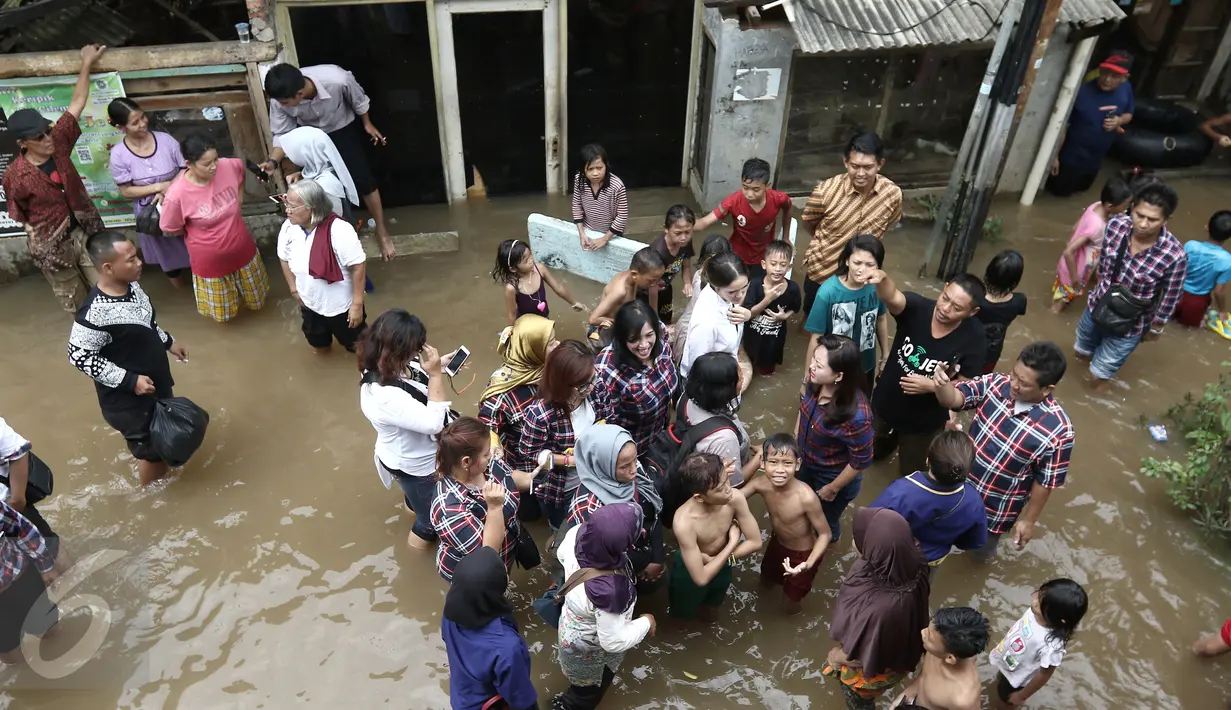 Cathy Sharon bersama Heppy Farida meninjau lokasi banjir di kawasan Pancoran, Jakarta Selatan, Selasa (21/02). Cathy Sharon dan Heppy Farida Djarot meninjau lokasi banjir dan menyalurkan sumbangan untuk korban banjir. (Liputan6.com/Herman Zakharia)