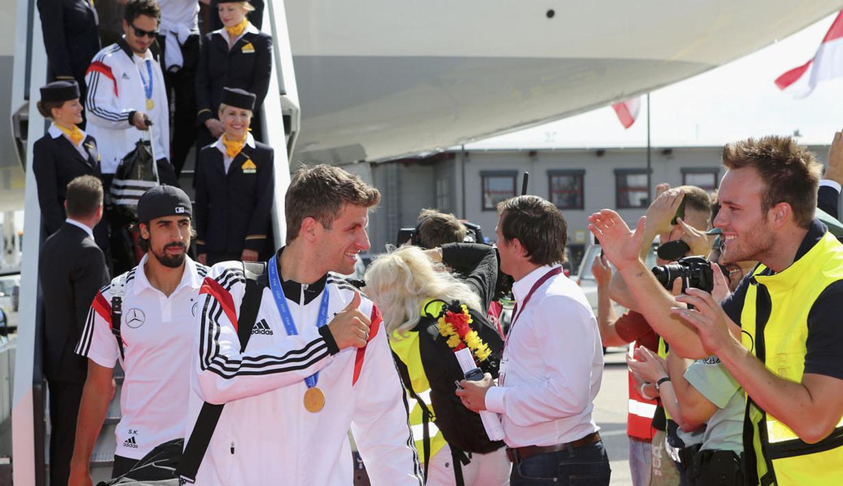 Pemain depan Timnas Jerman, Thomas Mueller, memberikan acungan jempol kepada para suporter sesaat setelah mendarat di Bandara Tegel, Berlin, (15/7/2014). (REUTERS/Karina Hessland/Pool)