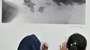 Siswa SD Negeri Menteng 01 menulis keterangan pada salah satu karya foto dalam pameran fotografi Rekam Jakarta di Taman Menteng, Kamis (29/8/2019). Kegiatan tersebut dalam rangka edukasi bagi siswa mengenal profesi foto jurnalistik. (merdeka.com/Iqbal S Nugroho)