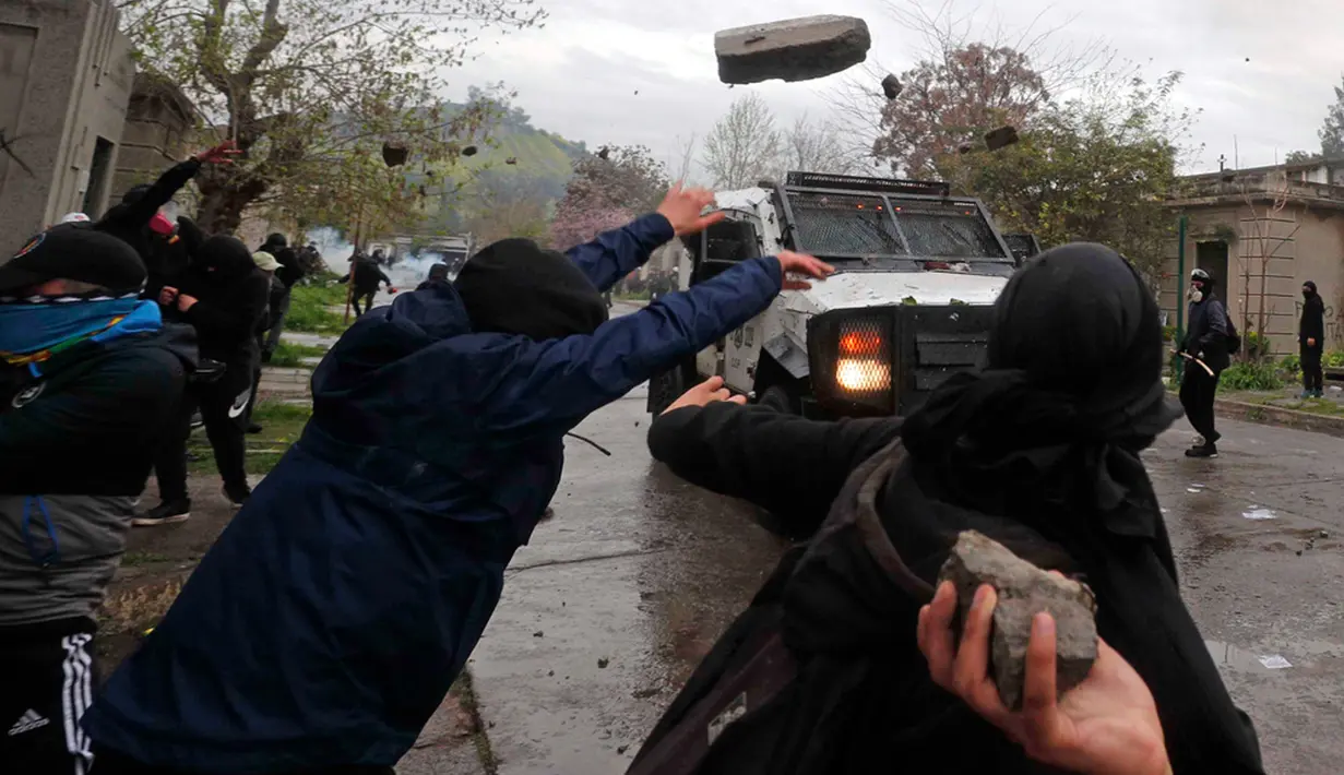 Para pengunjuk rasa juga melempari polisi dengan batu. (AP Photo/Luis Hidalgo)