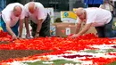 Sejumlah sukarelawan menata Karpet Bunga Brussels di Grand Place, Brussels, Belgia, Kamis (16/8). Lebih dari 500 ribu bunga digunakan untuk menciptakan karya tersebut. (AP Photo/Virginia Mayo)