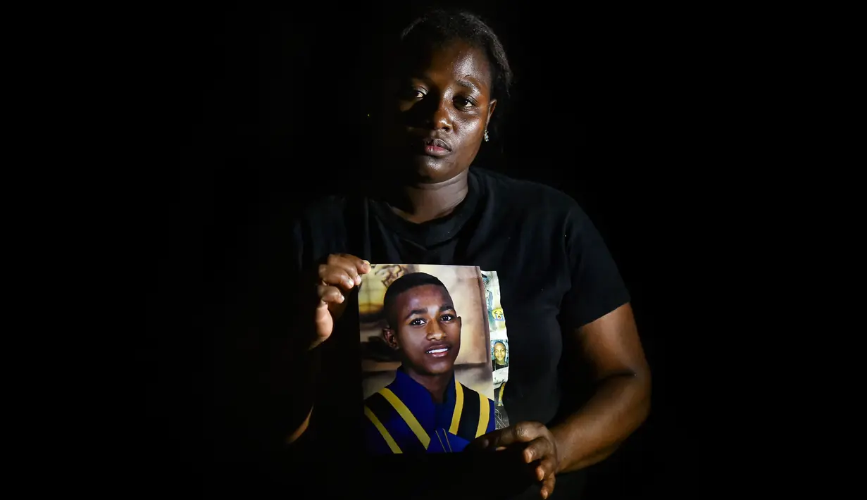 Nancy Quinonez, 30, ibu dari Luis Motano, 15, satu dari 5 pemuda yang dibunuh pada 12 Agustus dan ditemukan di ladang tebu dekat rumah, berpose dengan foto putranya di Cali pada 31 Agustus 2020. Pembunuhan kembali berdarah di pedesaan Kolombia. Korbannya kebanyakan masih muda. (Luis ROBAYO/AFP)