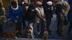 Orang-orang menunggu dengan hewan peliharaan mereka untuk diberkati saat pesta Santo Antonius di Pamplona, Spanyol, 17 Januari 2022. Pesta santo pelindung hewan Spanyol ini dirayakan setiap tahun dan orang-orang membawa hewan peliharaan mereka ke gereja untuk diberkati. (AP Photo/Alvaro Barrientos)
