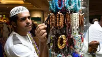 Jemaah haji memilih gelang yang dipajang di sebuah toko di kota suci Makkah, Arab Saudi pada Selasa (6/8/2019). Puncak Ibadah haji masih beberapa hari lagi, namun jemaah sudah memborong aneka barang antara lain tasbih, baju, teko emas, kurma, sajadah, minyak wangi, dan lainnya. (FETHI BELAID/AFP)