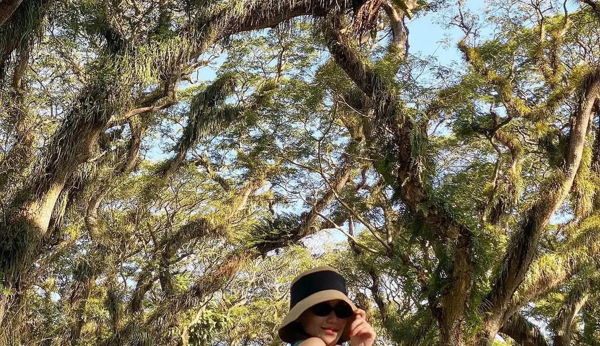 Perpaduan warna dan model busananya tampak sangat unik. Ia mengenakan topi dan kacamata hitam untuk menghadapi cuaca yang cukup terik. [Instagram.com/ayutingting92]