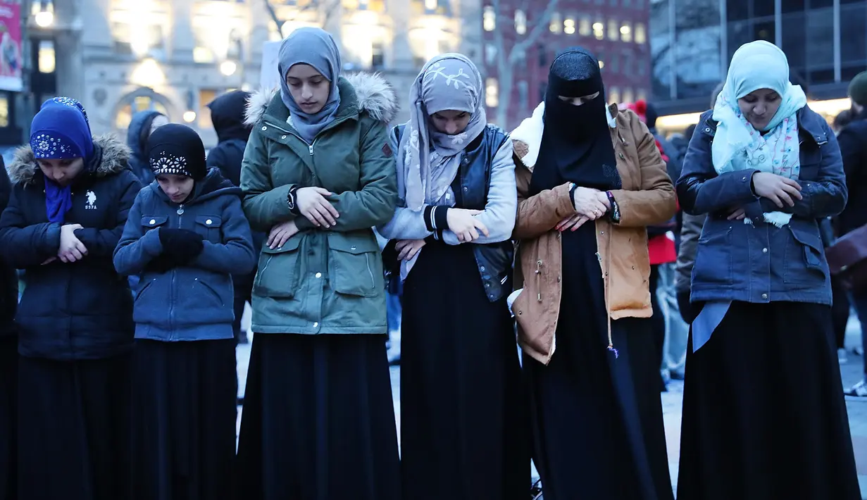 Wanita muslim menggelar salat berjemaah sebelum melakukan aksi protes di Manhattan, New York (1/2). Mereka melakukan protes terkait larangan imigran dari negara mayoritas muslim masuk ke AS. (AFP/Spencer Platt)