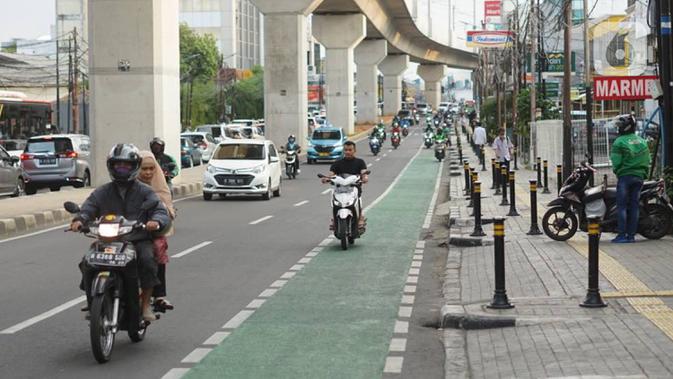 Pengendara sepeda motor melintasi jalur khusus sepeda di Jalan Fatmawati Raya, Jakarta, Rabu (22/1/2020). Kurangnya penerapan sanksi menyebabkan jalur khusus bagi pesepeda tersebut tidak steril dari kendaraan bermotor. (Liputan6.com/Immanuel Antonius)