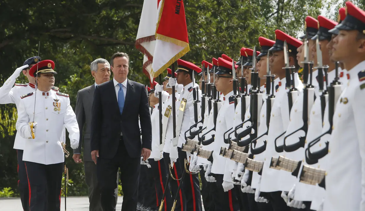 PM Inggris David Cameron  ditemani PM ketiga Singapura Lee Hsien Loong menginspeksi barisan tentara dalam seremonial penyambutan di Istana Kepresidenan Singapura, Rabu (29/7/2015). Inggris ingin perkuat kerja sama dengan negara ASEAN. (REUTERS/Edgar Su)