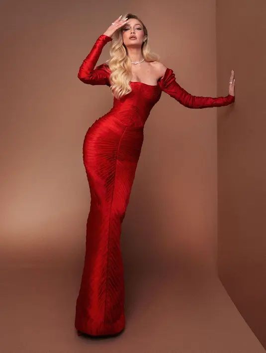 Gigi Hadid dengan gaun merah, berlengan panjang tampil luar biasa di foto ini. Column dress ini memiliki lengan seperti disambung, dipadu dengan kulit putih dan rambut blondenya, Gigi Hadid pancarkan aura alpha female yang menawan. Foto: Instagram.